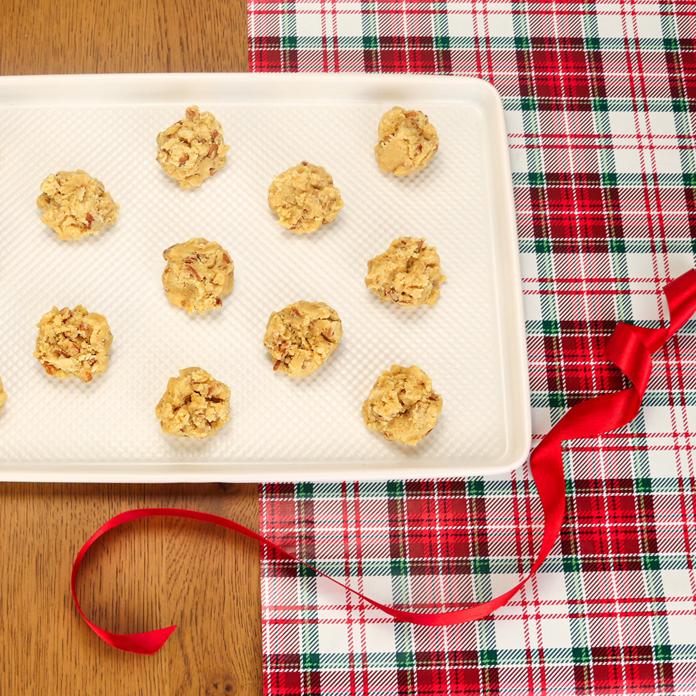 Cookie Dough on a tray with a red ribbon on a holiday background