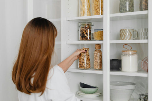 A woman organizing her pantry, probably thinking about ordering delicious fresh cookies from David's Cookies